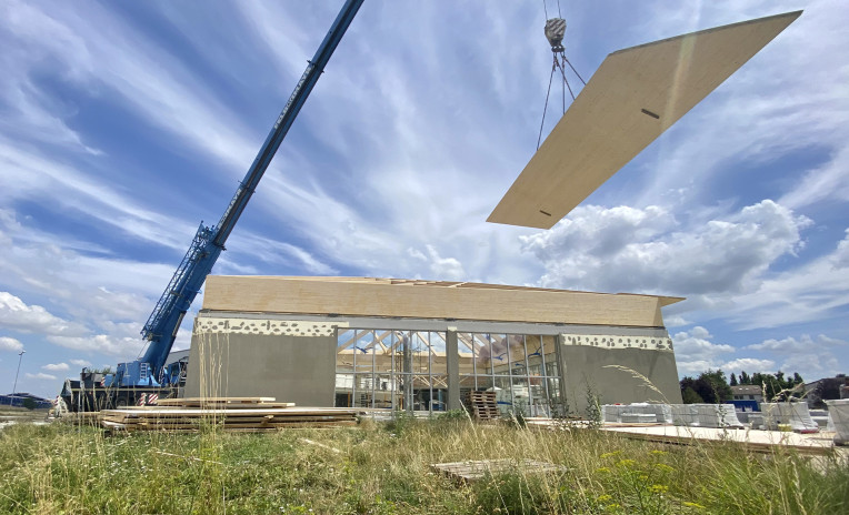 Crane lifting prefabricated timber roof panel on construction site using lifting systems for wooden prefabricated buildings