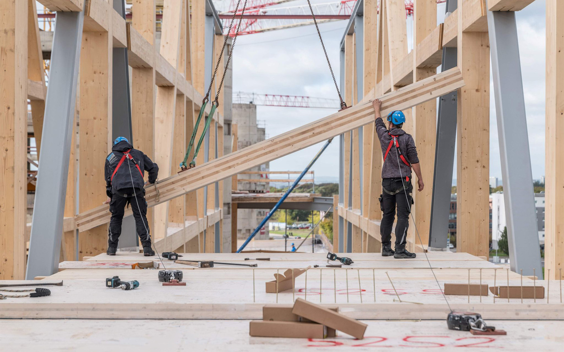 Mass timber construction site with workers installing structural timber elements in a sustainable building project 